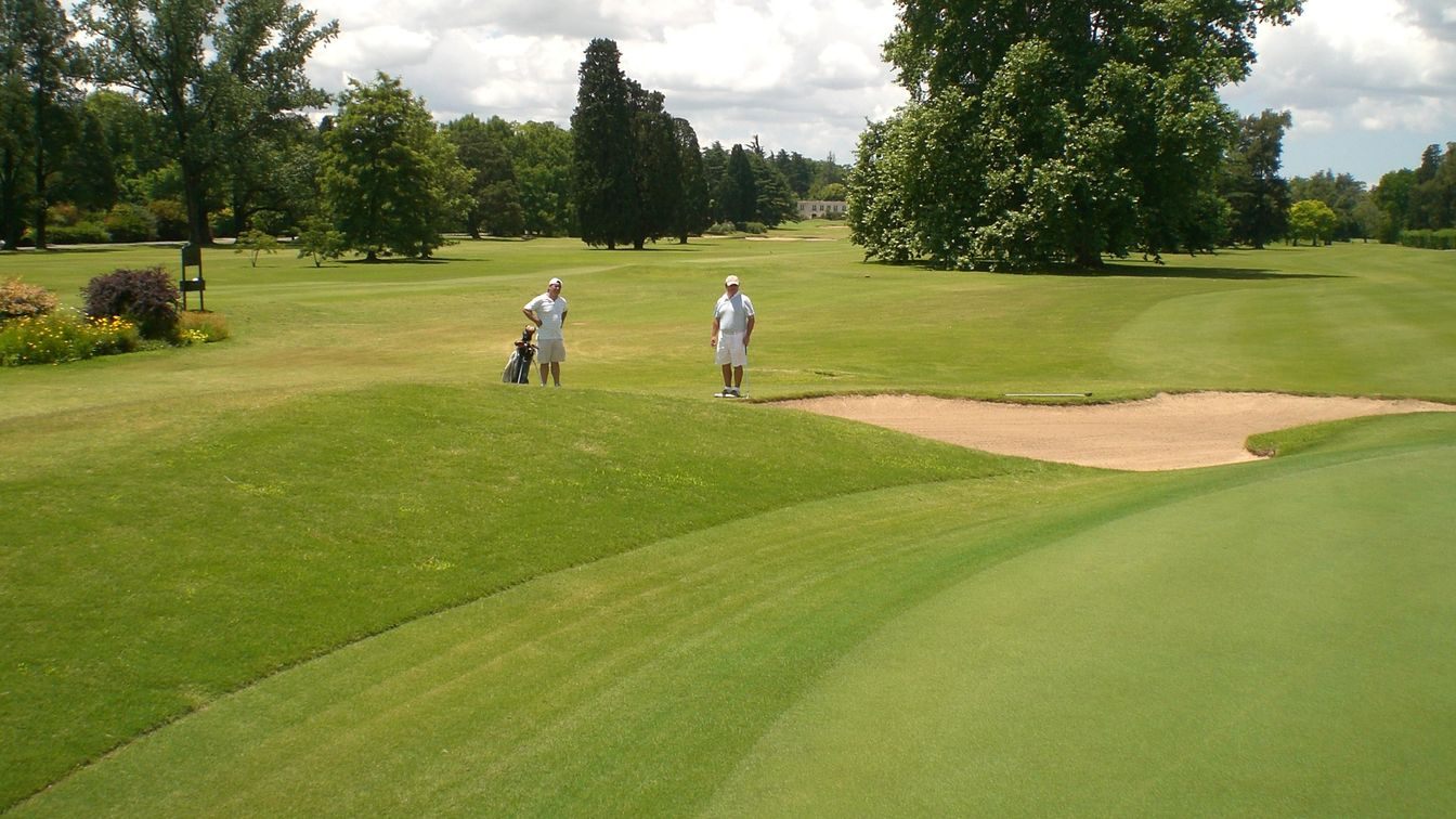 Two members reading a putt on a bunkered green